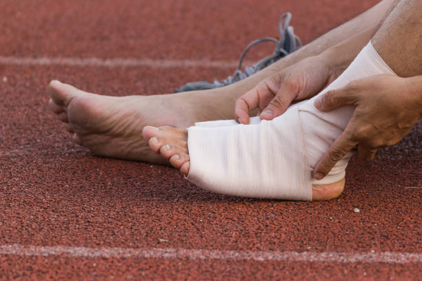 istock Male athlete applying compression bandage onto ankle injury 950904936