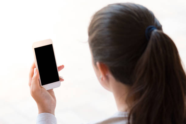 young woman looking at the smartphone, isolated on white background stock photo