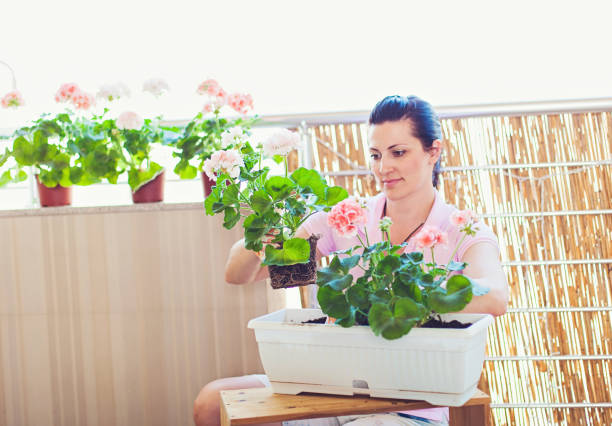 Happy Young Woman Gardening on a Balcony