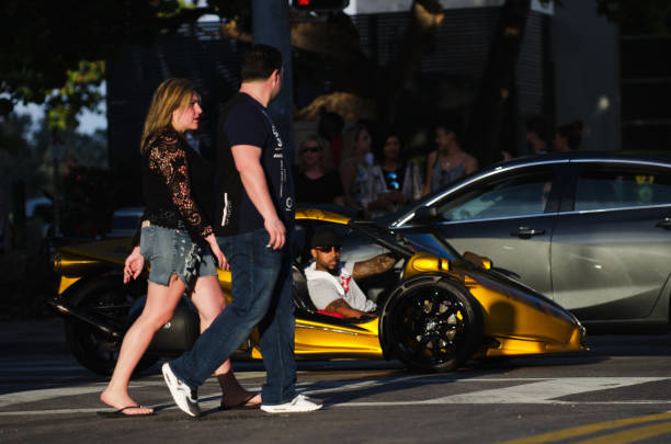 Miami - April 21, 2018: A gold three-wheel motorcycle catches eyes as it drives along Ocean Drive in South Beach, a popular Saturday night activity.