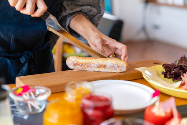 istock Woman cutting bread for lunch party 950922324