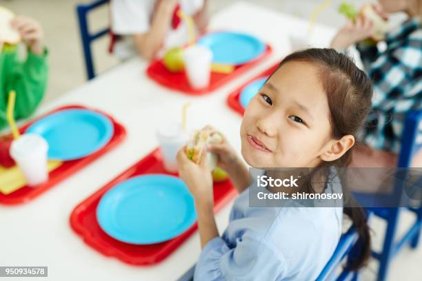 Photo libre de droit de Coinrepas Scolaire Manger Fille Heureuse banque d'images et plus d'images libres de droit de Enfant - Enfant, Cantine scolaire, Niveau de scolarisation