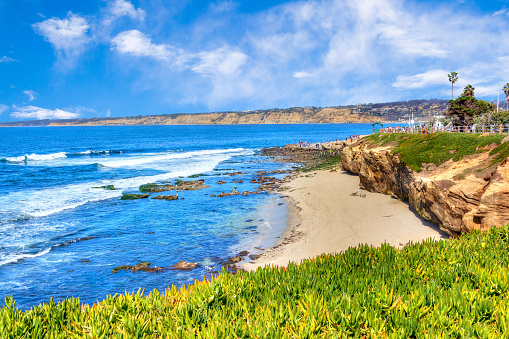 Sunny late afternoon at the popular scenic seaside town of La Jolla Cove beach in San Diego, California.