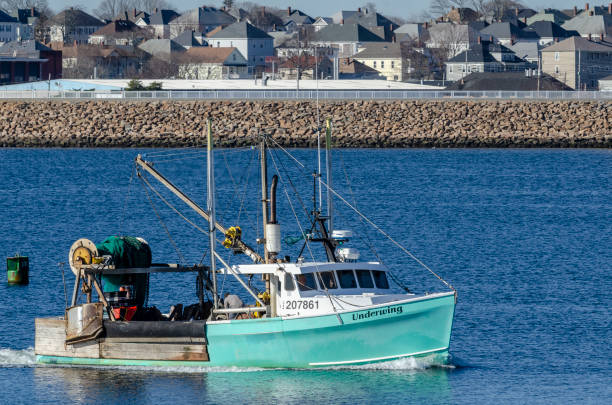 fishing boat underwing with hurrican barrier in background - hurrican imagens e fotografias de stock