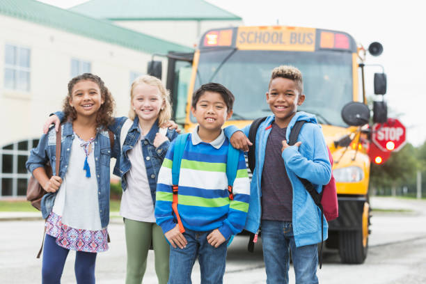 istock Elementary children standing in front of school bus 950953522