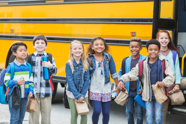 istock Elementary school children waiting outside bus 950953550