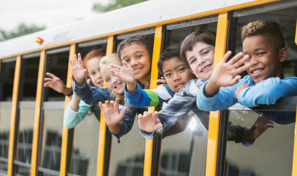 istock Elementary school children looking out window of bus 950955800