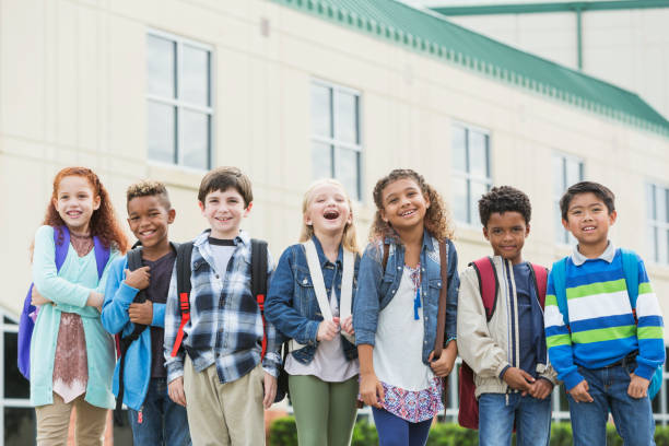 istock Multi-ethnic school children standing outside building 950955968