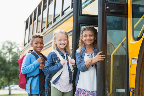 istock Multi-ethnic school children standing outside bus 950955990