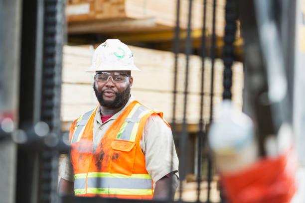 homme afro-américain travaillant dans une cour à bois - minority african ethnicity business hardhat photos et images de collection