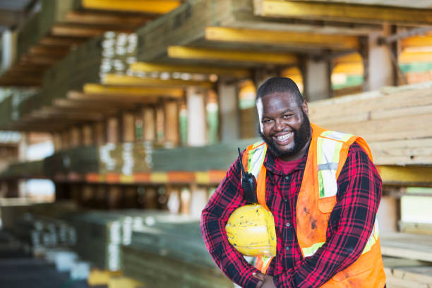 afrikanisch-amerikanischer mann arbeitet in einem holzlager - minority african ethnicity business hardhat stock-fotos und bilder