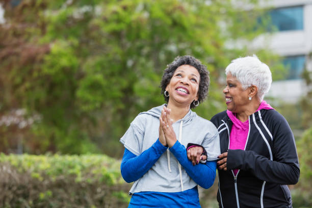 istock Two African-American women laughing together, praying 950961020