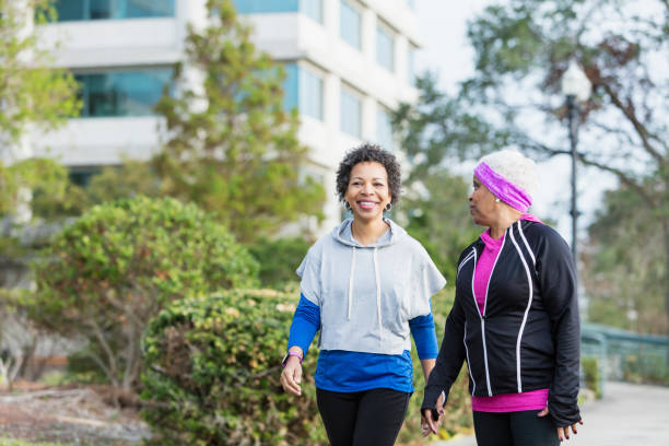 istock Two mature women talking and walking for exercise 950961548
