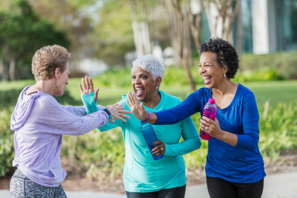 istock Three mature women in park talking, laughing playfully 950961780