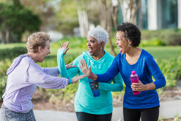 istock Three mature women in park talking, laughing playfully 950961880
