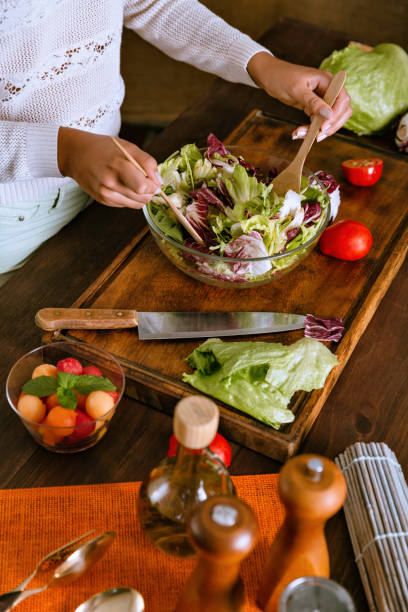 здоровое питание - молодая женщина руки сделать веганский салат с органическими ингредиентами в деревенской кухне - fruit salad fruit healthy eating making стоковые фото и изображения