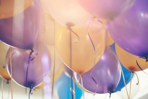 Balloon in birthday party background.Multi colour (yellow,blue,violet,purple) helium Ballon with string and ribbon in celebrate wedding day.Concept of balloon in wedding and birthday party.