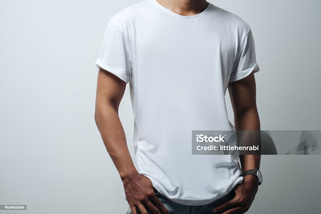 man in white blank t-shirt man in white blank t-shirt, empty wall, studio  casual style T-Shirt Stock Photo