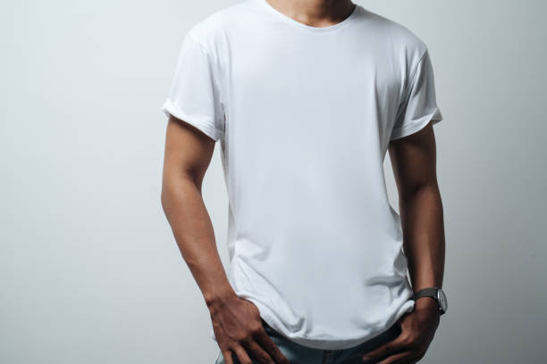man in white blank t-shirt man in white blank t-shirt, empty wall, studio  casual style blank t shirt stock pictures, royalty-free photos & images