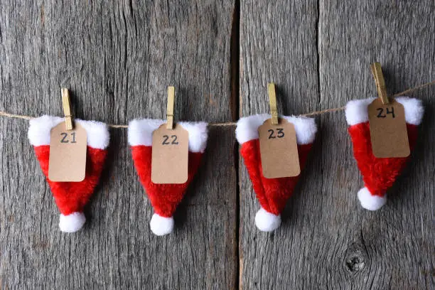 Advent Calendar made of Santa hats clothes pins and string.