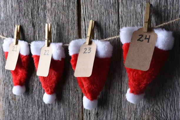 Advent Calendar made of Santa hats clothes pins and string.