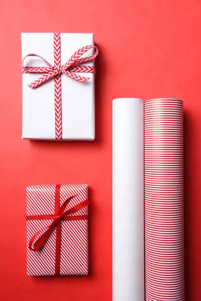 Two Wrapped Christmas presents with matching paper rolls and copy space.