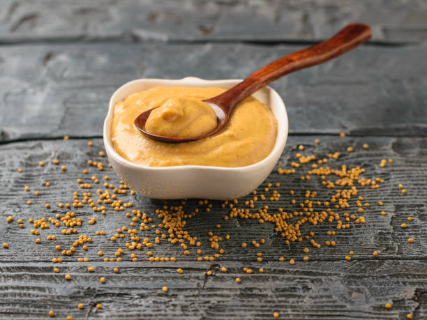 istock Freshly made mustard sauce and seeds on a wooden table. 950970874