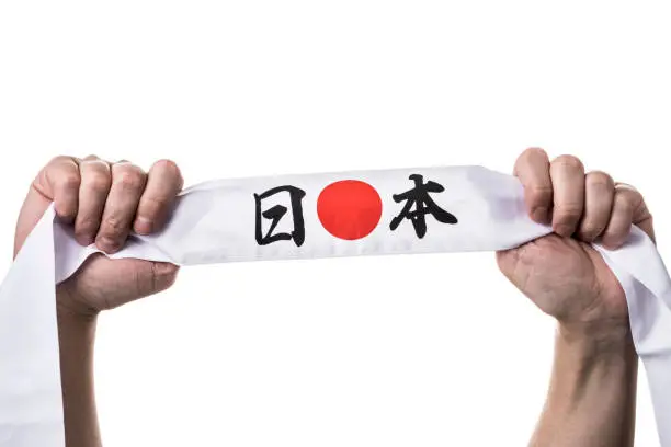 Male hand holding head band of Japanese national flag