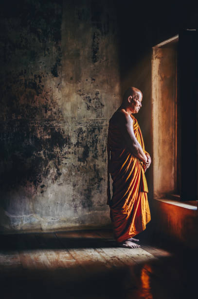 istock Buddhist monks are standing in front of windows in the morning light. 950978682