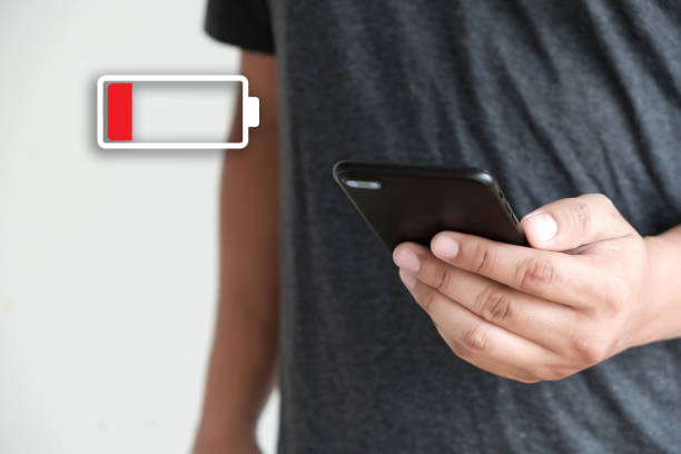 istock Close up man hands using smart phone battery low charged battery screen 950979374