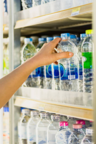 istock woman's hand  pick product from  convenience store refrigerator shelves 950981730