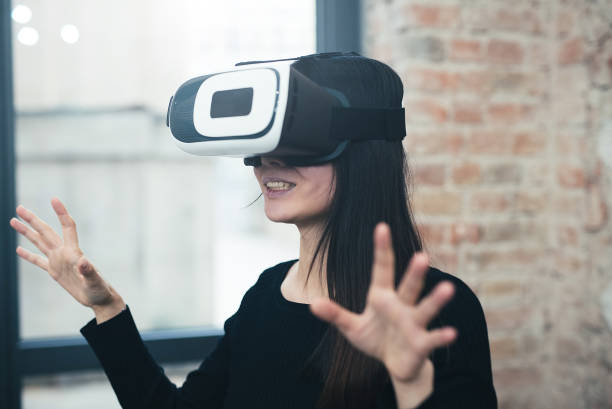 istock Young woman looks fascinated into Virtual Reality Headset 950983380