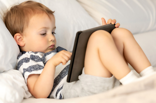 male toddler looking at his electronic tablet