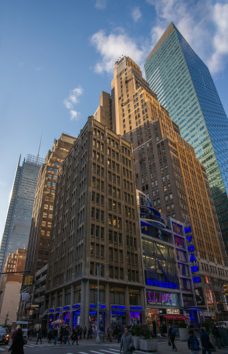 New York, U.S.A. - April 20, 2018: Midtown Skyscrapers from masonry to glass and metal facades in setting sun against blue sky