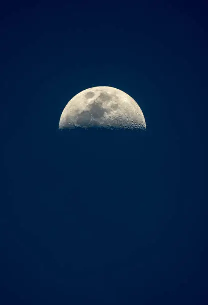 half moon in blue night sky during the month of Vesak in April