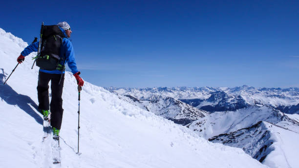 mężczyzna narciarz backcountry będzie na stoku śniegu w backcountry alp szwajcarskich na wycieczkę narciarską w zimie - silvretta zdjęcia i obrazy z banku zdjęć