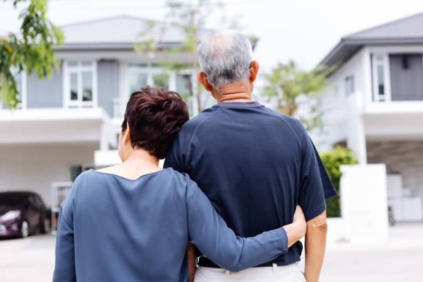 feliz pareja senior por detrás mirando en frente de casa y coche - coche doméstico fotografías e imágenes de stock