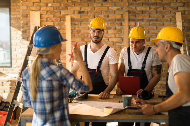 istock Female building contractor giving instructions to group of workers on construction site. 950996756