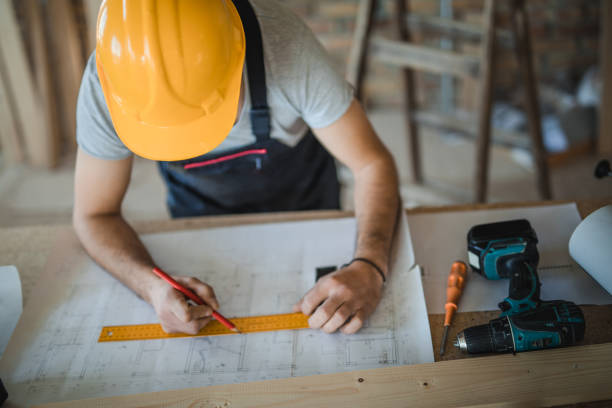 istock Above view of construction worker drawing additional improvements on blueprints in the apartment. 950996888