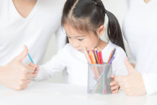 istock Cute girl working on her school project at home. 950999540