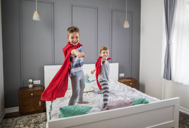 istock Joyful boys playing superheroes in a bedroom. 951000010
