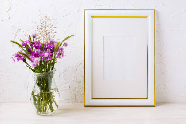 istock Gold decorated frame mockup with purple burdocks in glass 951000426