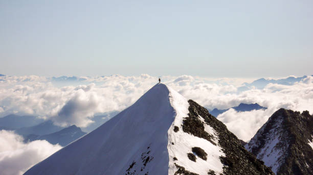 альпинист стоит на изолированном хребте саммита с отличным видом позади - piz palü стоковые фото и изображения