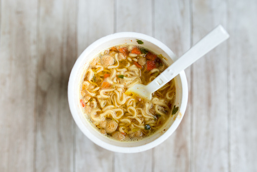 instant noodles, noodle soup in a cup, view from above. Instant noodlesÂ are sold in a precooked and dried noodle block, with flavoring powder and/or seasoning oil. The flavoring is usually in a separate packet, although in the case of cup noodles the flavoring is often loose in the cup.