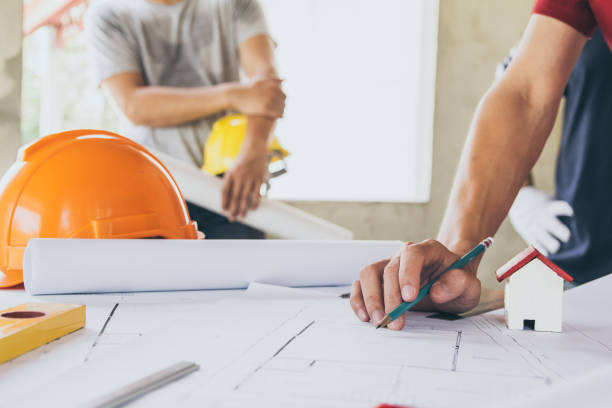 istock Concept architects,engineer holding pen pointing equipment architects On the desk with a blueprint in the office, Vintage, Sunset light.Selective Focus 951006444