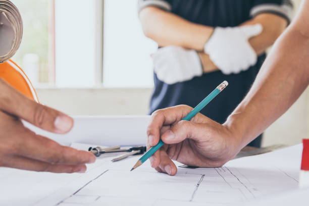 istock Concept architects,engineer holding pen pointing equipment architects On the desk with a blueprint in the office, Vintage, Sunset light.Selective Focus 951006652