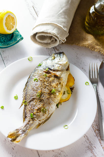 istock Dorada baked and stuffed with lemon on a white plate 951006828