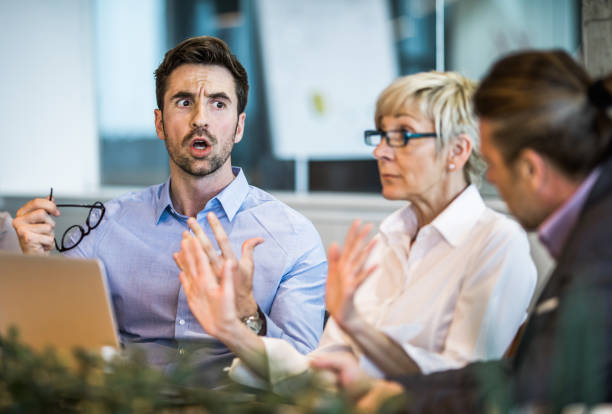 Young businessman arguing with his colleague on a meeting in the office. Frustrated entrepreneur discussing with his colleague on a business meeting in the office. displeased stock pictures, royalty-free photos & images