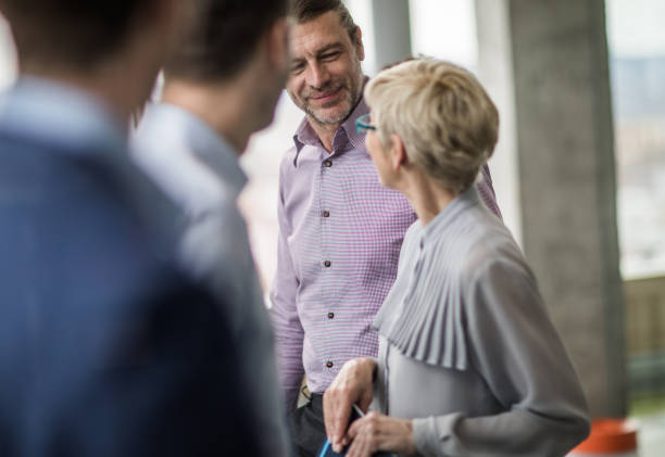 istock Smiling businessman talking to his colleague while walking in a hallway. 951013456