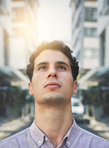 istock Inspired: a young office worker looks up as he walks in the city 951017522